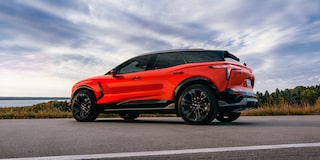 A 2027 Chevy Blazer EV SS Parked on an Open Road Showcasing a Sporty Side Profile, Black Alloy Wheels, a Contrasting Roof, and Athletic Exterior Styling.