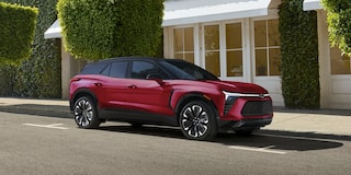 A 2027 Chevy Blazer EV RS Parked in a Residential Driveway With Black Alloy Wheels, a Contrasting Roof, and Athletic Exterior Styling Visible From a Front Three-Quarter Angle.