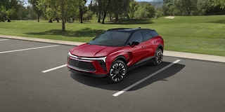 A 2027 Chevy Blazer EV RS Parked in an Outdoor Lot Showcasing Black Alloy Wheels, Athletic Body Lines, and Distinctive Front-End Styling From a Front Three-Quarter View.