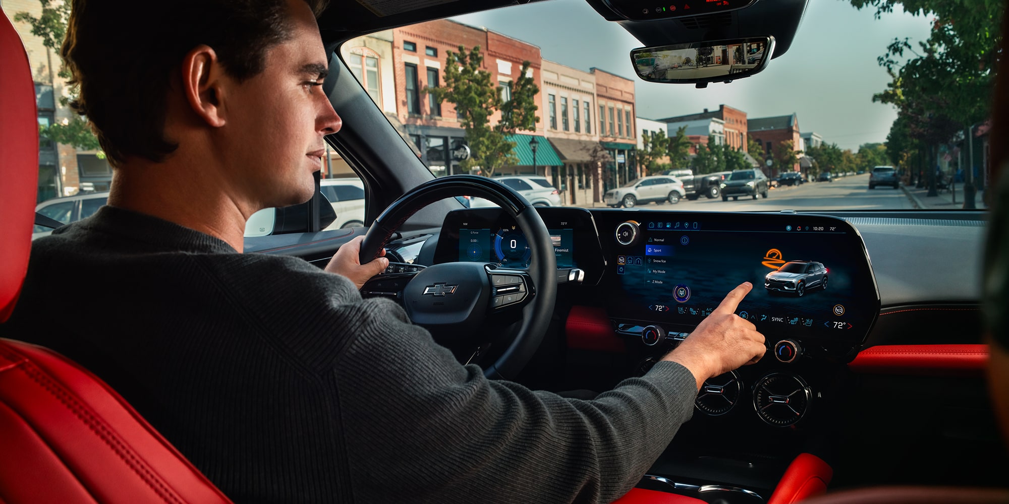 A Driver Interacting With the Infotainment Touchscreen Inside a 2027 Chevy Blazer EV SS Featuring Premium Interior Accents, Digital Displays, and a Modern Driver-Focused Cabin.