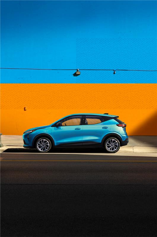 2027 Chevrolet Bolt Parked in Front of an Orange Wall.