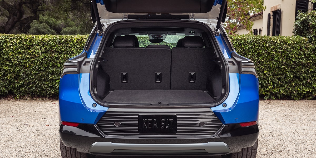 Rear View of Blue Equinox EV with its Truck Open While Parked on a Gravel Driveway