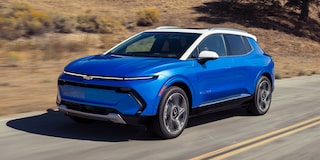 Vista de perfil de Equinox EV Azul andando por una carretera con efecto de movimiento