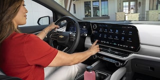 Una mujer interactúa con la unidad principal de Google de Equinox EV