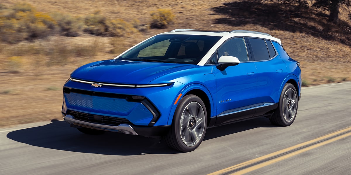 Side Profile of Blue Equinox EV Driving Down the Highway Surrounded with Motion Blur