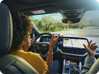 Vista trasera de una mujer habando con un pasajero mientras utiliza Super Cruise manos libres en un vehículo Chevy