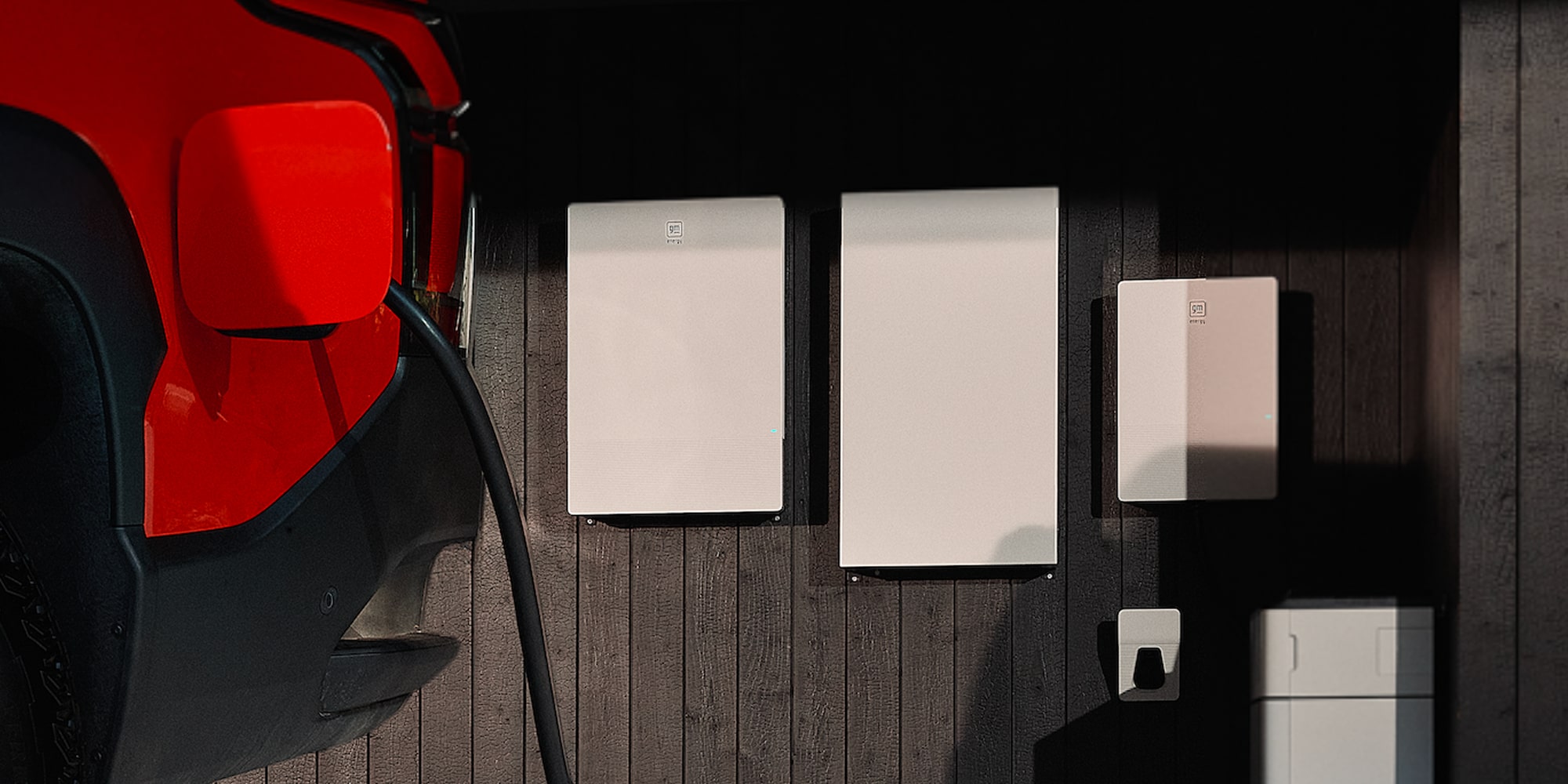 A Home Charging Station Mounted on an Exterior Wall Next to a Parked Chevy Silverado EV.
