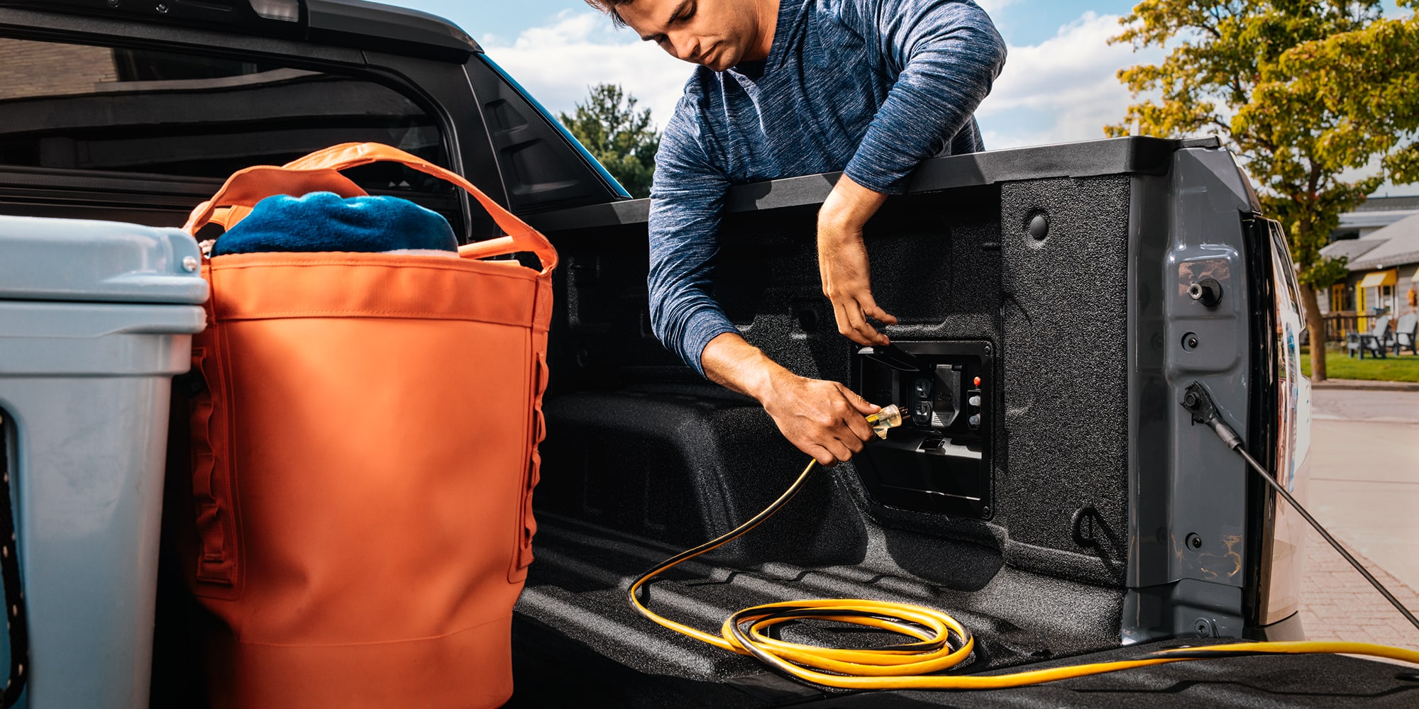 A Man Is Seen Plugging in the Charging Port inside the Cargo of a 2027 Chevy Silverado EV