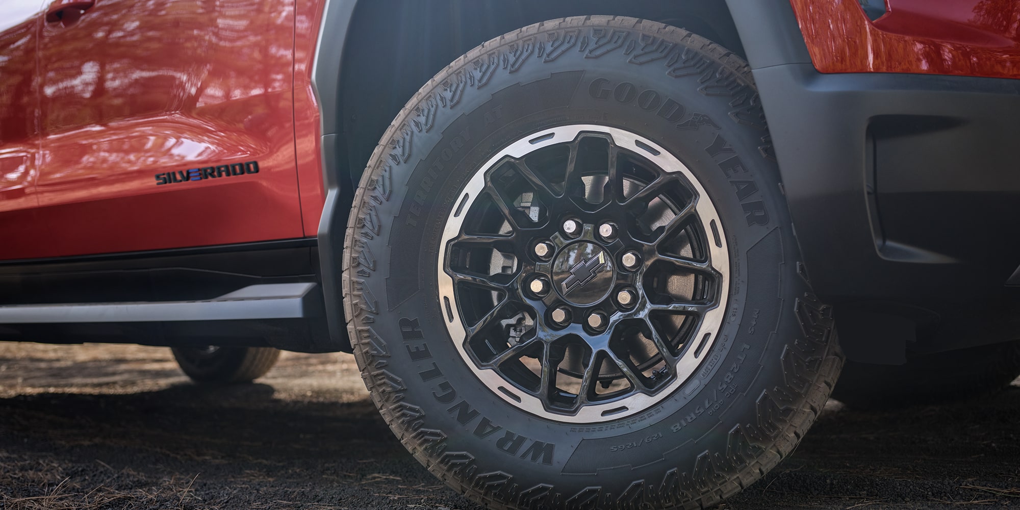 Three Quarters Rear View of a 2026 Chevy Silverado EV in Front of a Body of Water on a Sunny Day