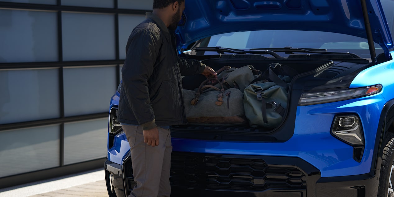 A Man Loading Bags into the Front Trunk Storage on the Silverado EV