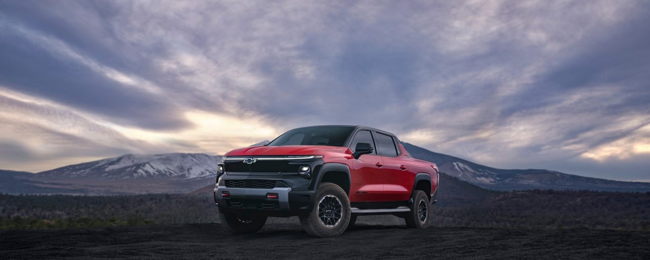 2026 Chevy Silverado Parked on Dark Rocky Terrain with a Dramatic Sky in the Background