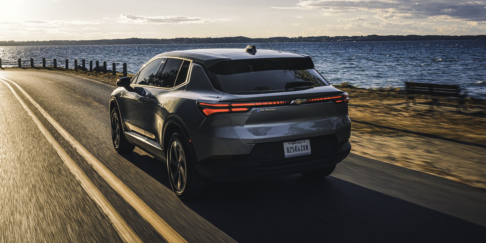 2026 Chevy Equinox EV Driving Next to a Lake at Sunset