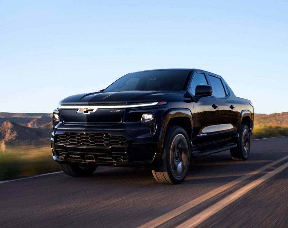 2025 Chevy Silverado EV Driving Down a Western Country Road
