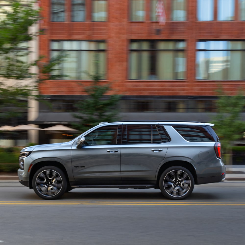 2025 Chevy Tahoe Side Profile View While Driving Through a Downtown Area