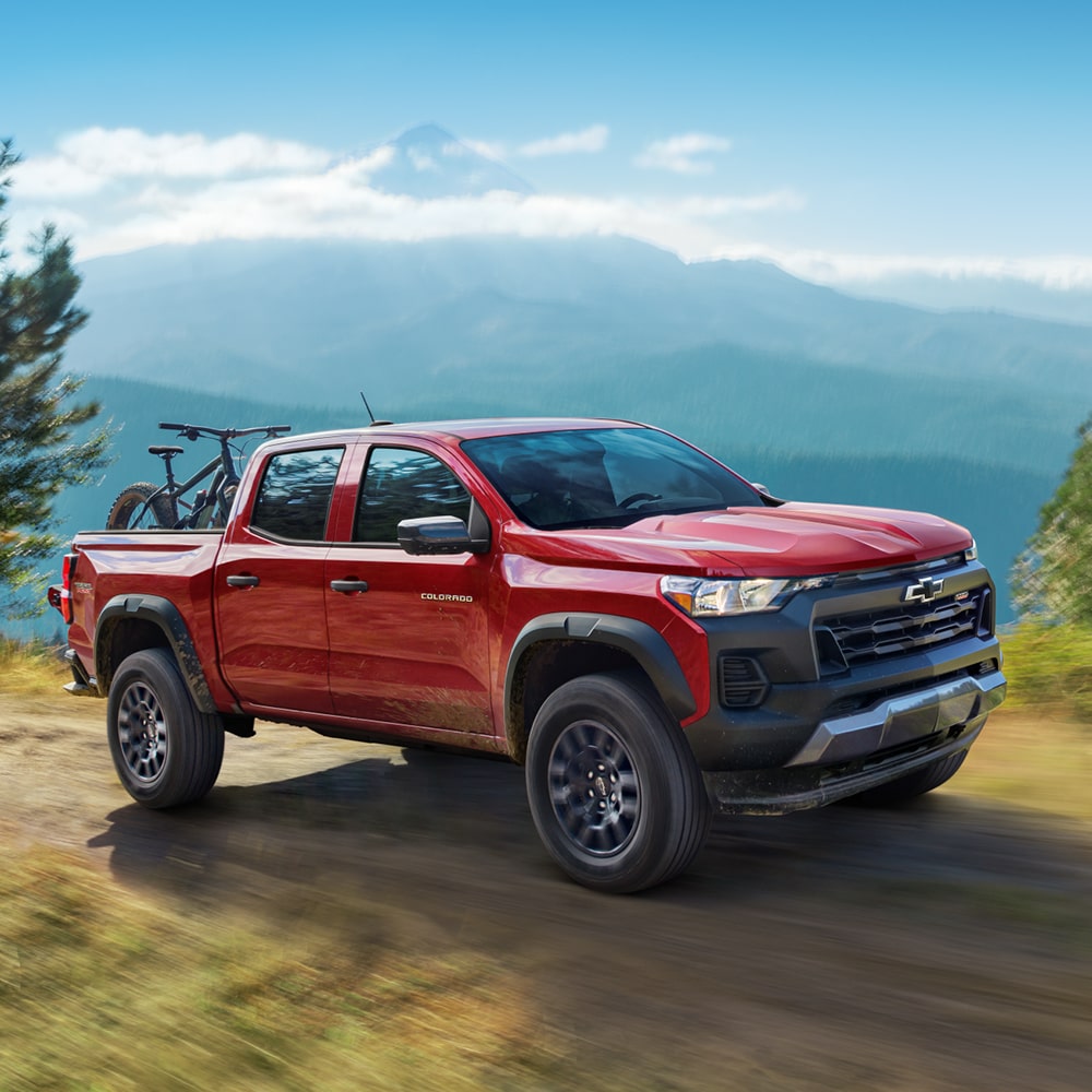 Una Chevy Silverado 1500 2025 estacionada fuera de carretera en un terreno rocoso con montañas cerca