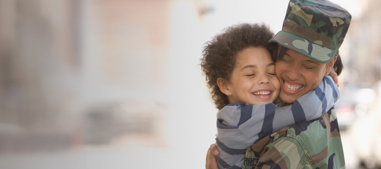 Close-up of a Military Member Reuniting with a Child While Hugging and Smiling
