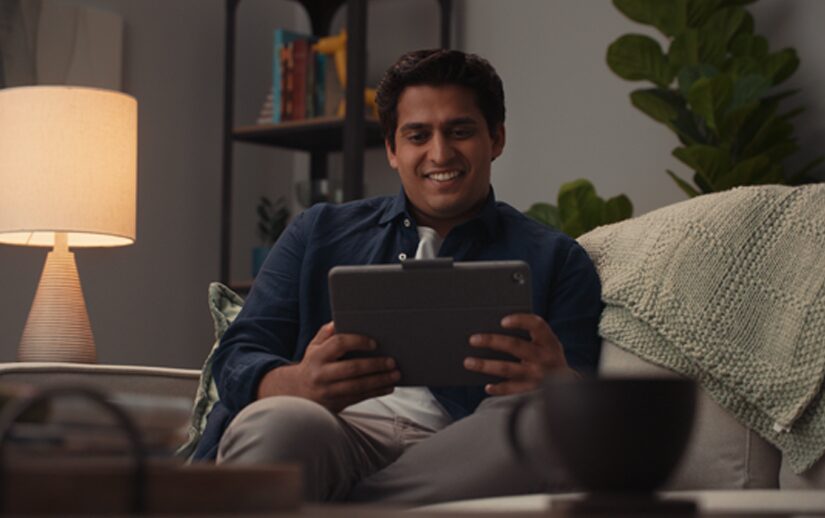 Man sitting on his couch holding a tablet