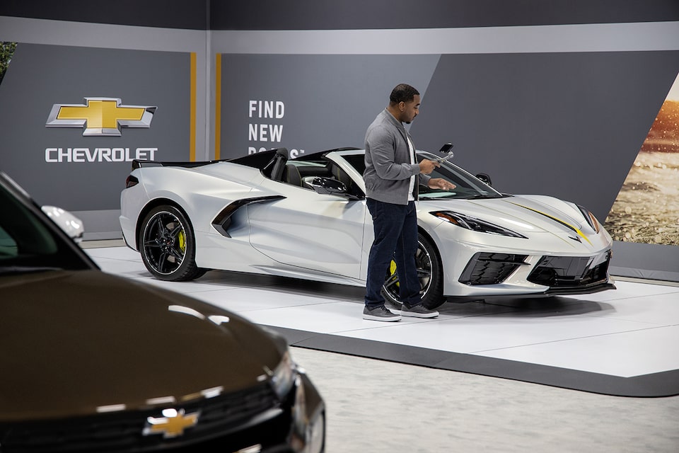 A Product Specialist using a mobile device to demo a 2022 Corvette. 