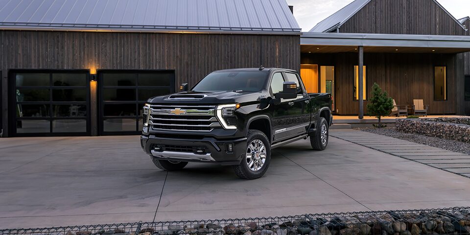 Toma nocturna de una Silverado HD negra estacionada fuera de una casa