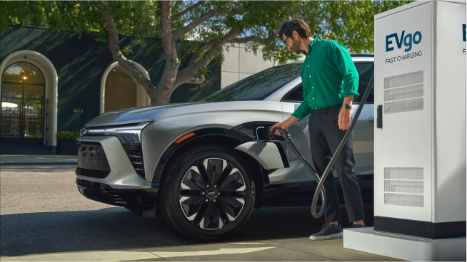 A Man Plugging in His Blazer EV at a Public Charging Station