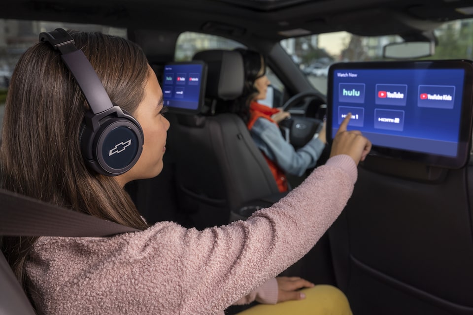 A Woman Drives Her Chevy Vehicle While Her Daughter Uses OnStar Wifi to Stream TV