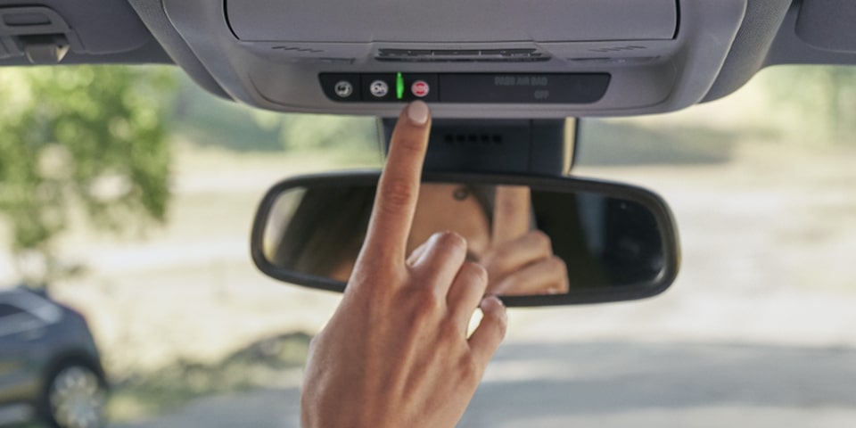 A Woman Presses the OnStar Button for Assistance