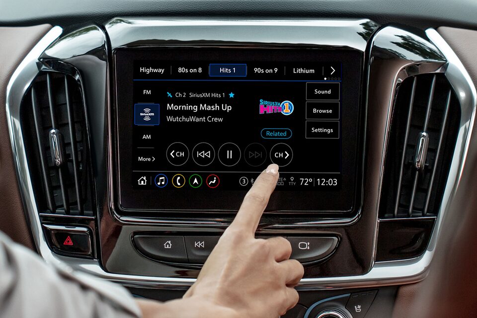 A Woman Browses Through Her Sirius XM Channels on the Infotainment System of a Chevy Vehicle