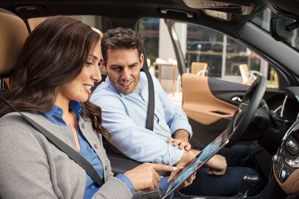 A Man & Woman Enjoy OnStar Wifi as They Browse Their iPad