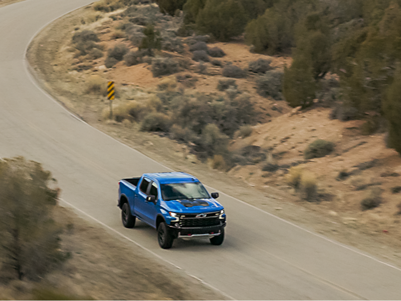 Bird's Eye View of a Blue Chevy Truck Driving Through a Mountain Road