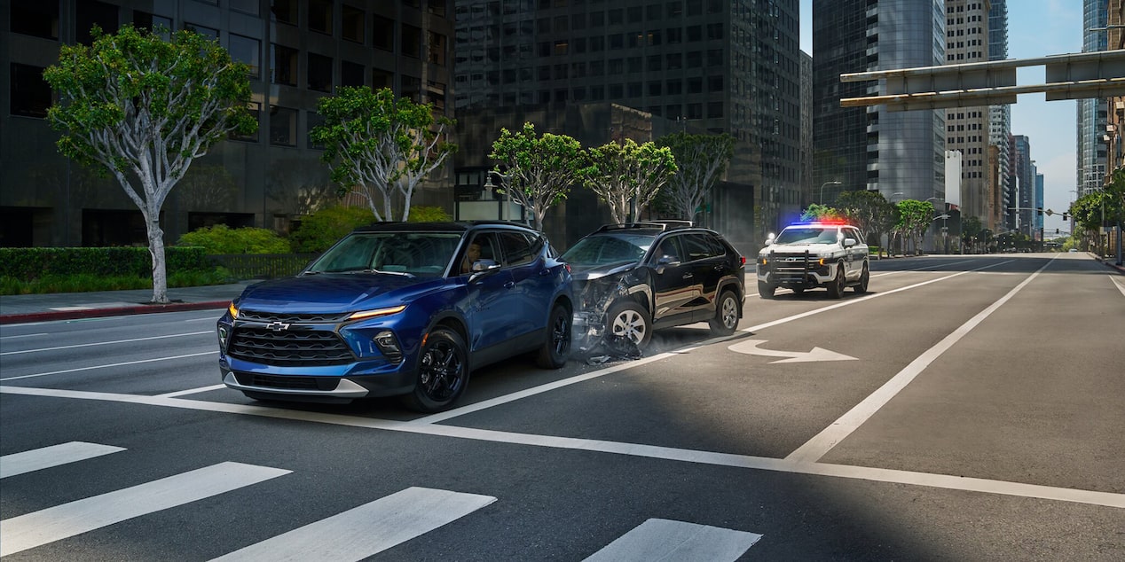 Vehículo Chevy en un accidente y una patrulla policial acercándose para brindar asistencia