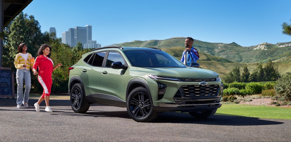 Una familia caminando hacia su Chevy Blazer estacionada en una entrada de garaje