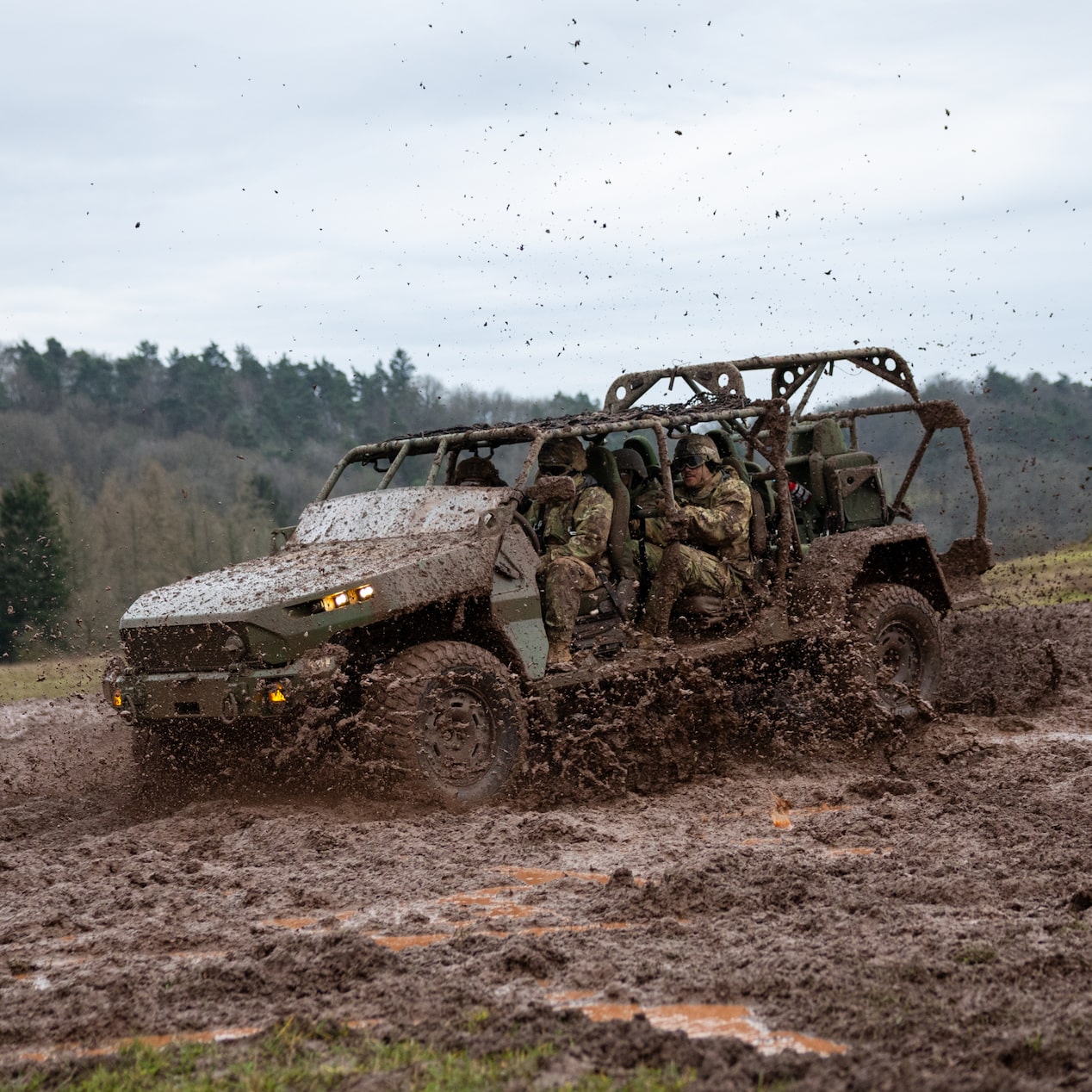 An Army Truck Full of Soldiers Driving Through a Muddy Terrain