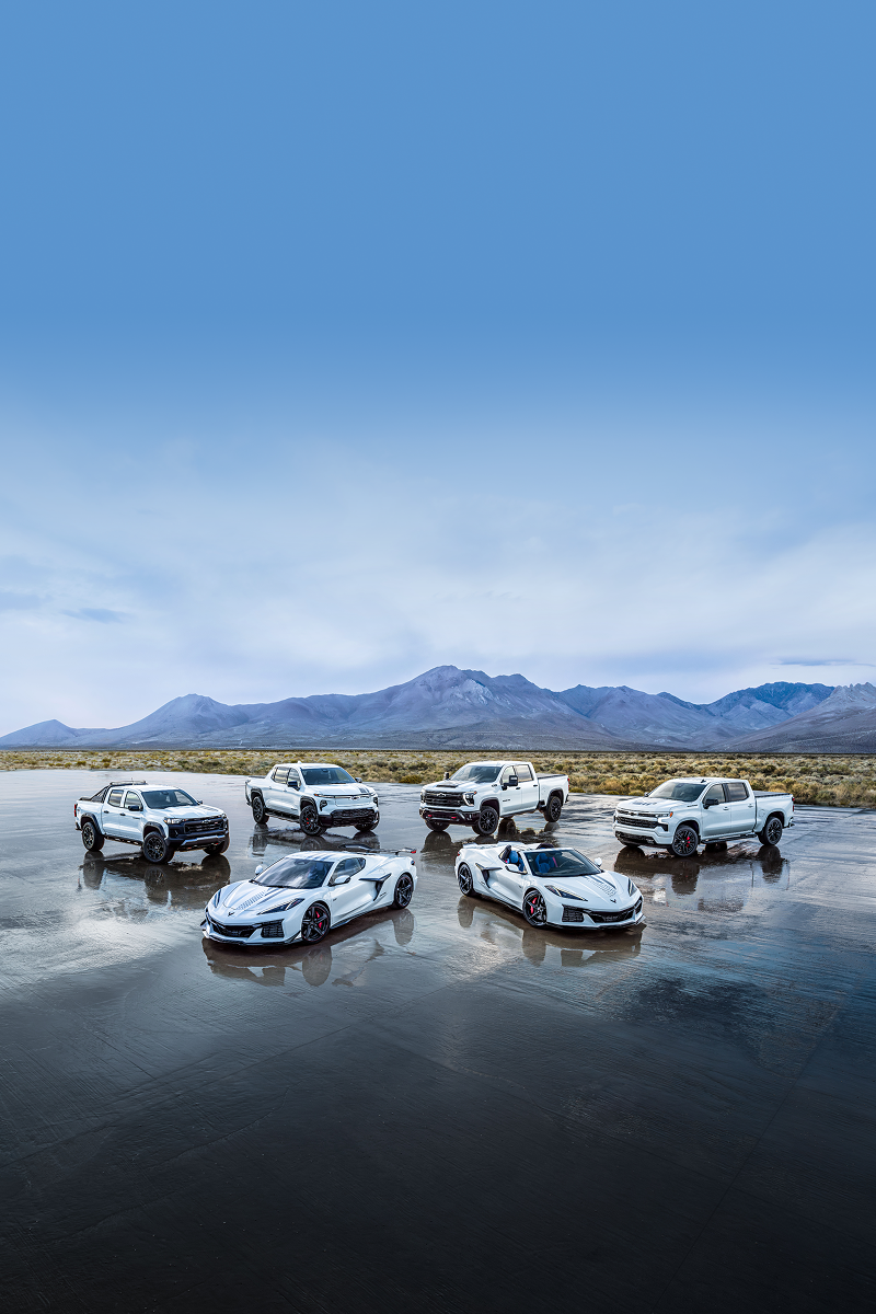A Collection of Chevrolet Stars and Steel Edition Corvettes and Trucks on a Wet Surface in a Desert.