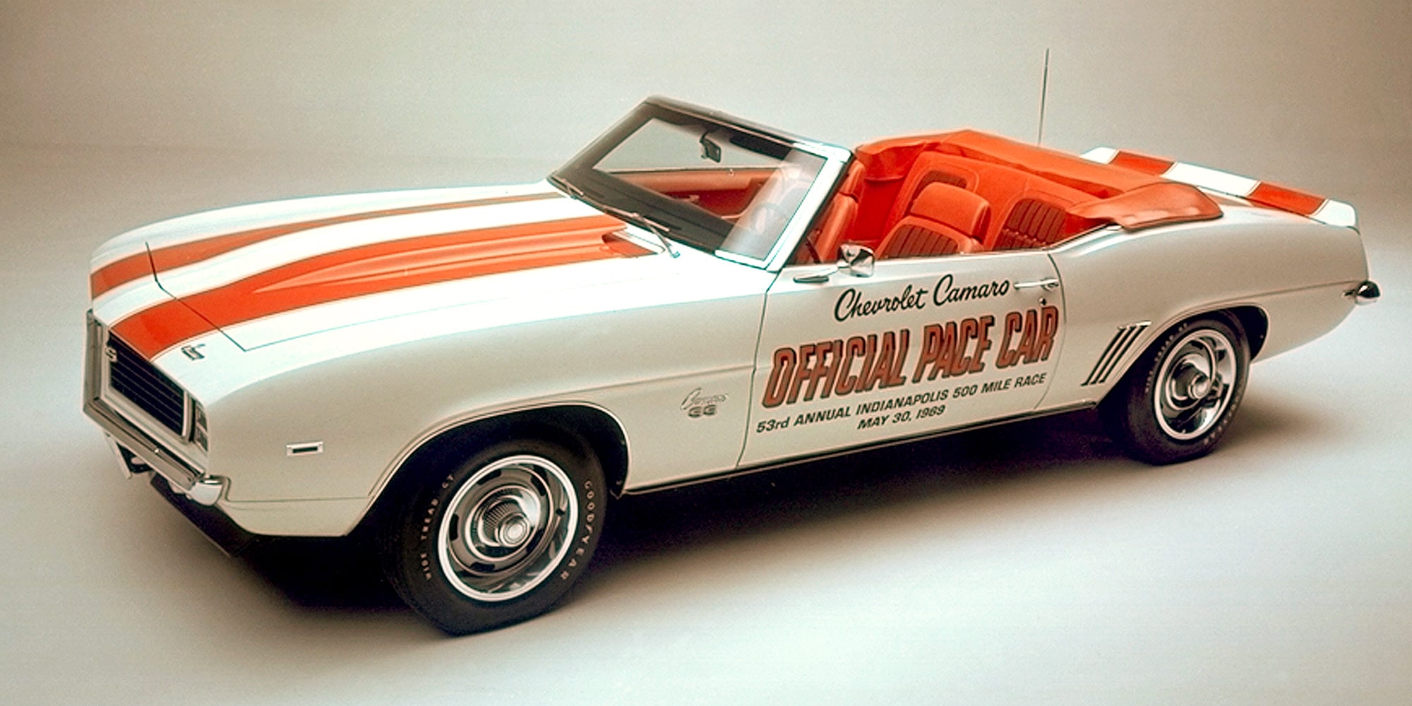Three Quarters View of a White Convertible Pace Car with Orange Racing Stripes in a Showroom