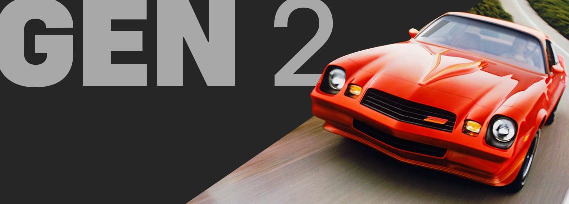 Front View of a Bright Orange Classic Chevy Camaro Driving on a Curving Highway, Captured in Motion