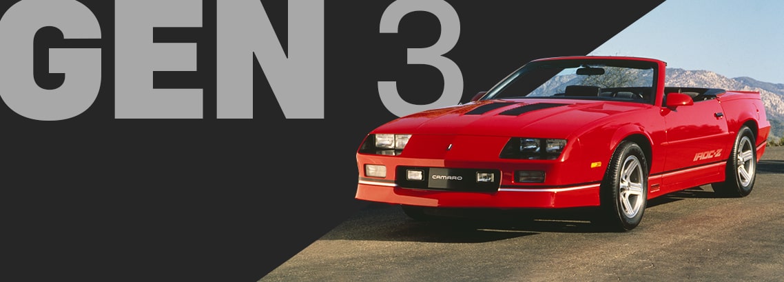 Bright Red Chevy Camaro Convertible Driving Down on a Sunlit Open Road with Distant Mountains