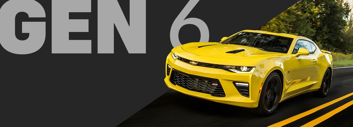 Front Angle View of a Bright Yellow Chevy Camaro Convertible Driving at Night