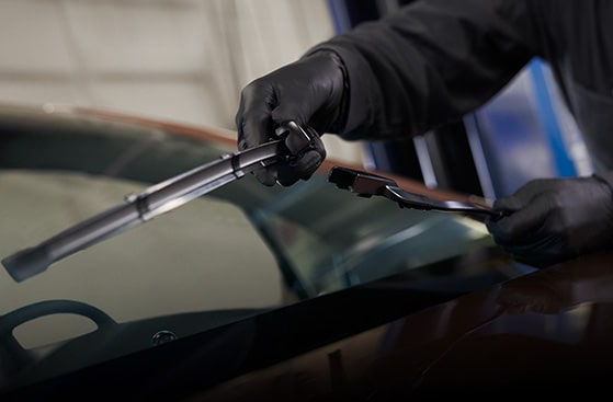 Mechanic Wearing Gloves Installing a New Windshield Wiper Blade on a Vehicle