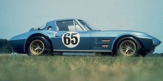 A Blue Chevrolet Corvette Race Car with Number 65 on the Door Driving on a Track.
