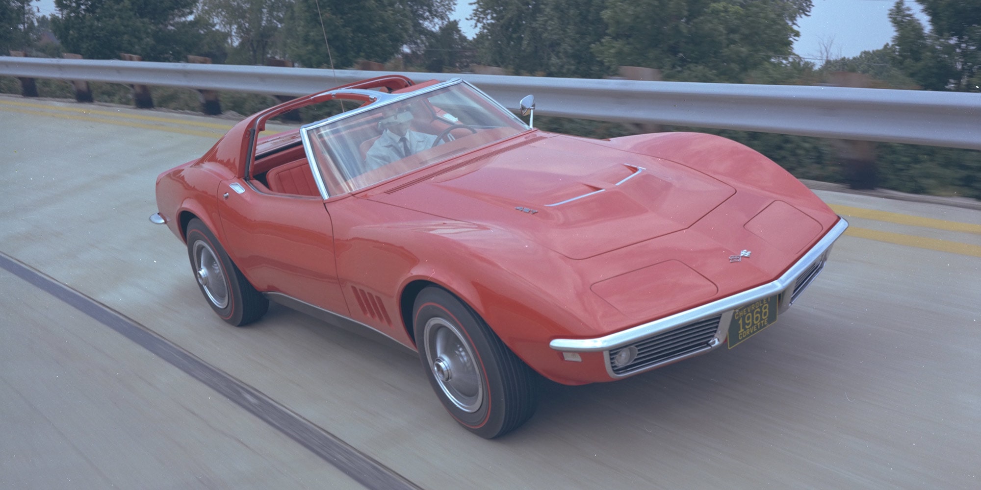 A Rear View of a Red Chevrolet Corvette Convertible with Chrome Bumper and Round Taillights.