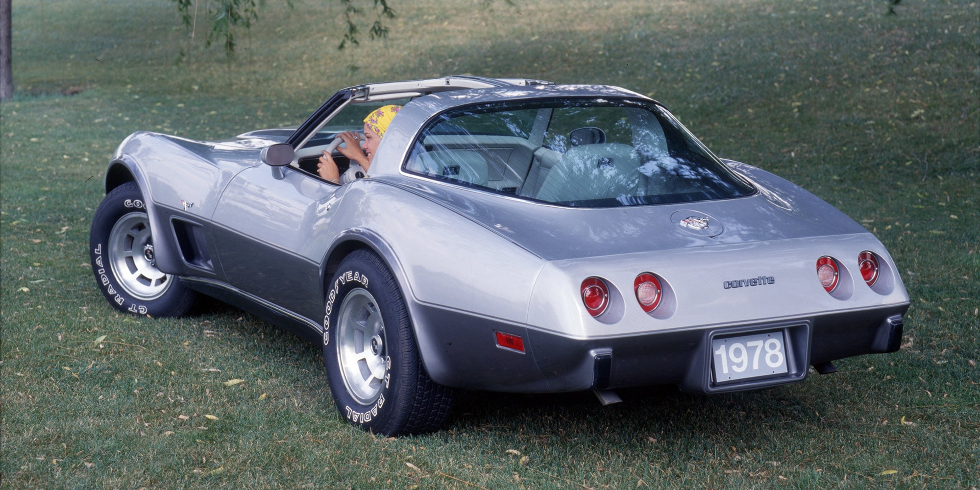 A Rear View of a Silver Chevrolet Corvette Convertible with Chrome Detailing and Dual Exhaust Pipes.