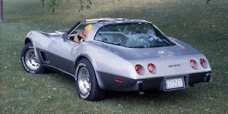 A Rear View of a Silver Chevrolet Corvette Convertible with Chrome Detailing and Dual Exhaust Pipes.