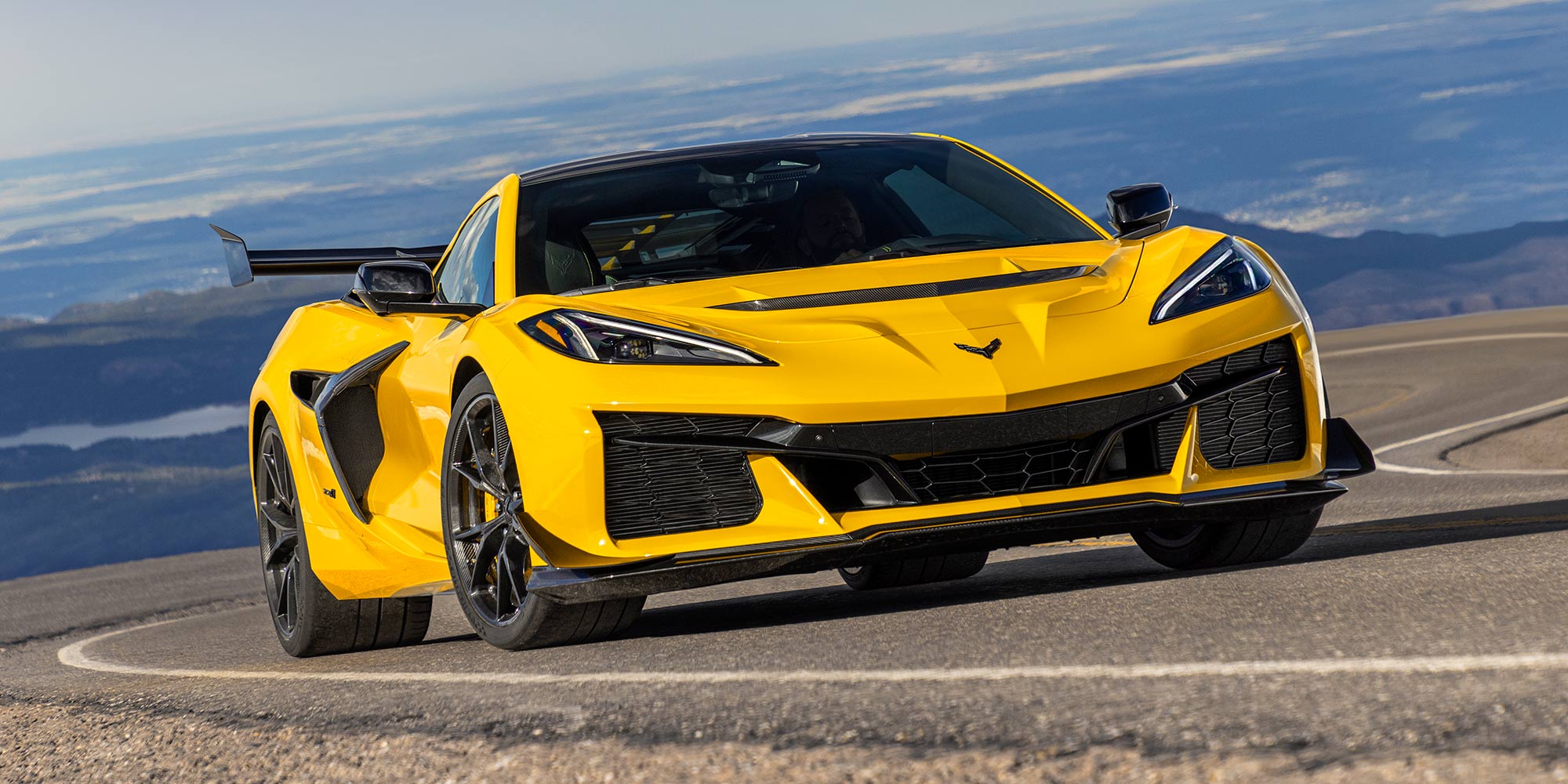 A Yellow Chevrolet Corvette Z06 Sports Car Positioned on a Desert Road with Black Wheels and Performance Styling.