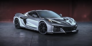 A Silver Chevrolet Corvette Z06 Displayed Indoors Under Dramatic Lighting with Glossy Black Wheels.