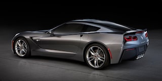 A Rear Three-Quarter View of a Gray Chevrolet Corvette Z06 Highlighting Quad Exhaust Pipes and Glossy Black Wheels.