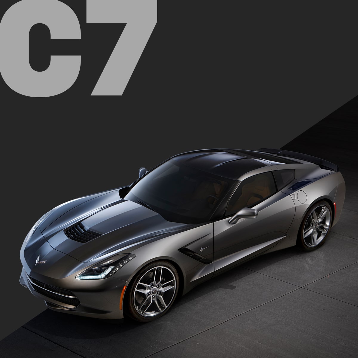 A Black Chevrolet Corvette C7 Coupe Displayed on a Dark Surface With Large Gray Text Reading “C7.”