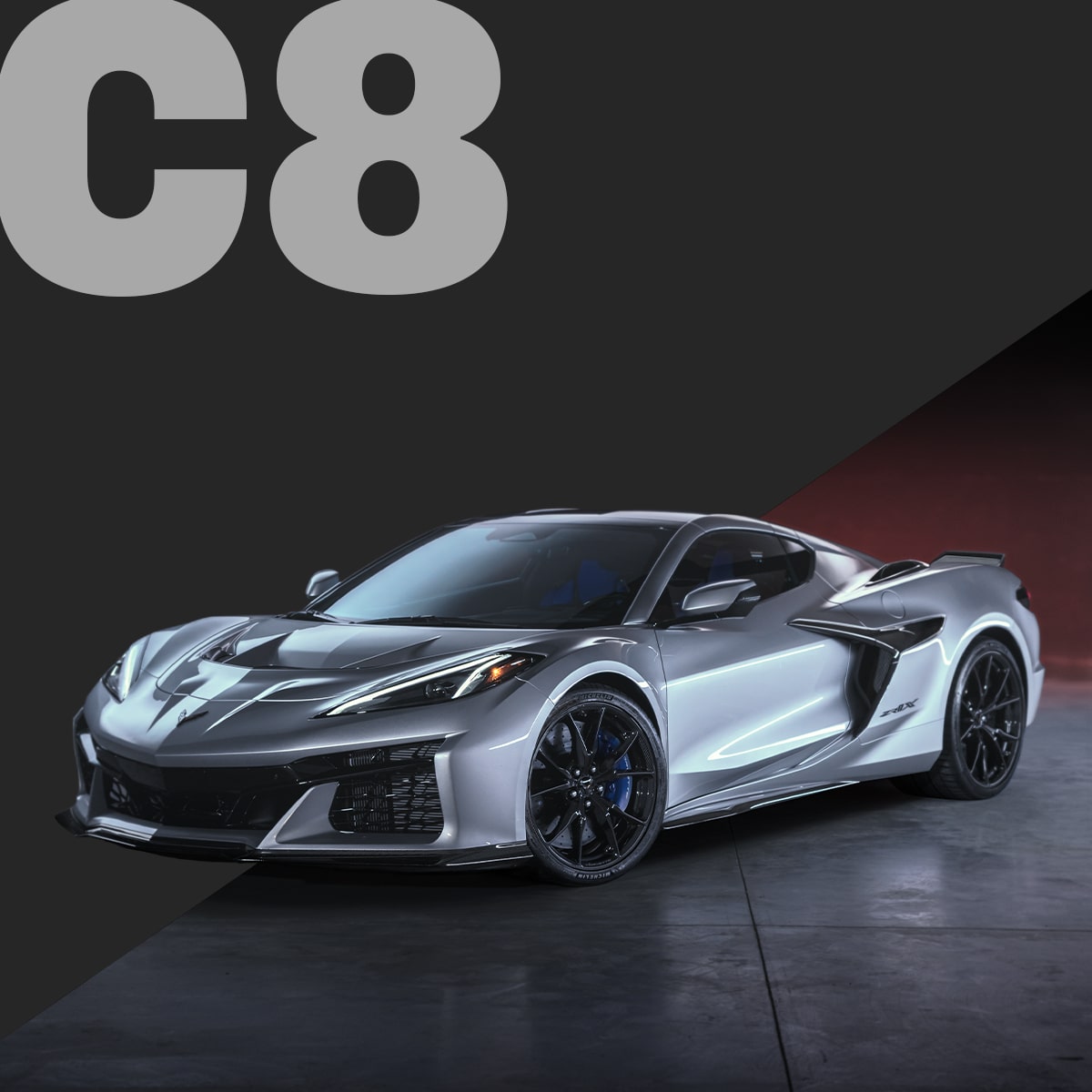 A Silver Chevrolet Corvette C8 Coupe Displayed on a Dark Surface With Red Lighting in the Background and Large Gray Text Reading “C8.”