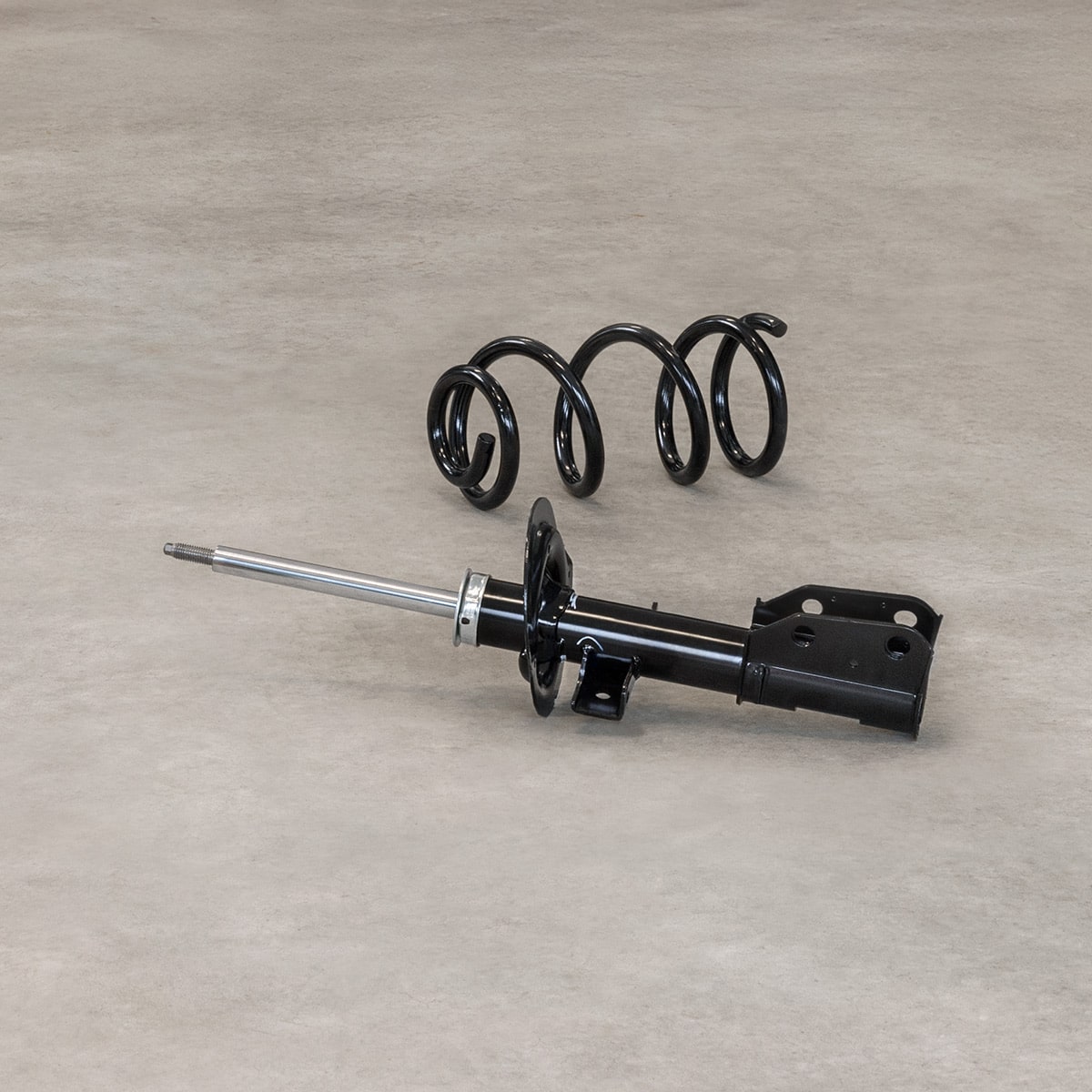 A Black Automotive Tool with a Long Metal Rod and Coiled Springs Positioned on a Light Surface with Text That Reads Shocks & Struts.