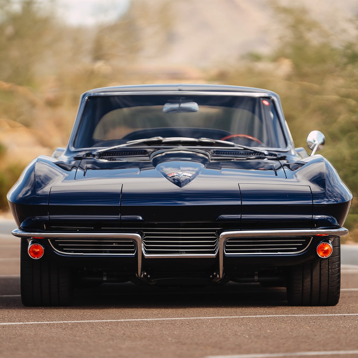 A Front View of a Dark Blue Classic Chevrolet Corvette Featuring Split Front Bumper and Chrome Detailing.