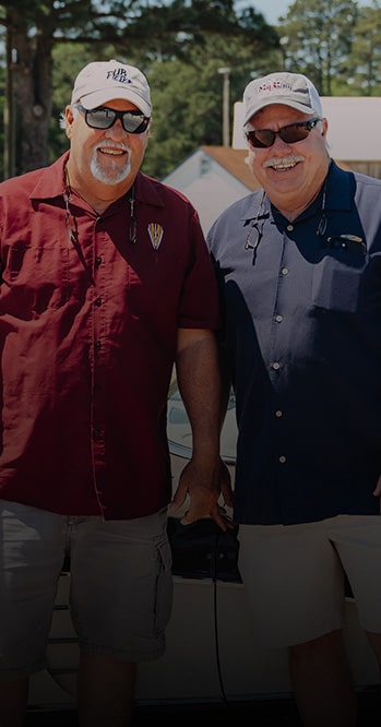 Two People Standing Outdoors With Trees in the Background and White Text Overlay Reading “I Don’t Think There’s Anything Else I’d Rather Have.” With the Names Scotty Hooper & Paul Atkins and “1968 Corvette” Below.
